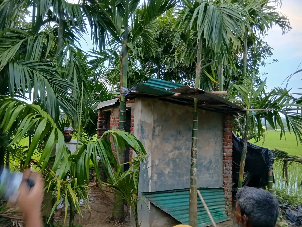 The rebuilt brick and corrugated-metal toilet beside the family's home