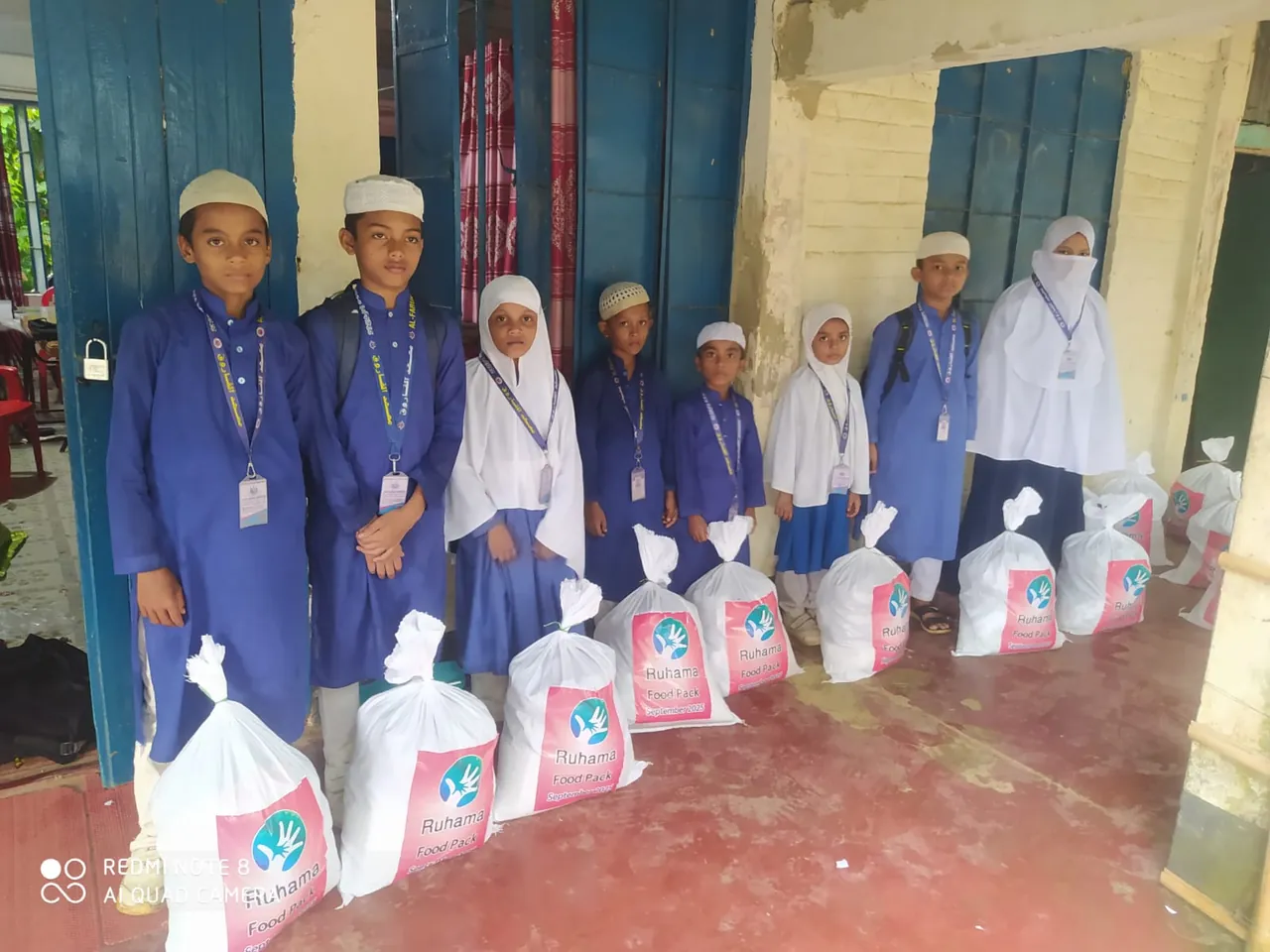 Children stand beside monthly Ruhama food packs in Bangladesh