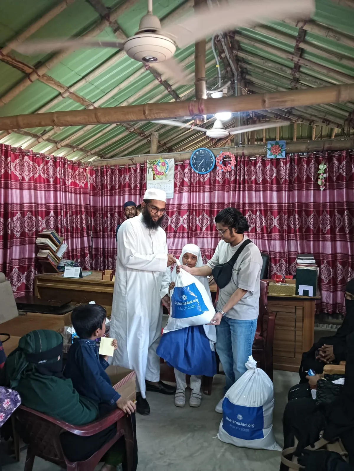 A child receives a Ruhama food pack during Ramadan 2026